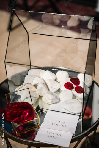 Quadro su tela Elegant glass box for wedding wishes or cards, featuring white decorative stones, red wax seals, and romantic I am yours, you're mine cards