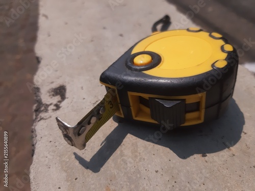 Yellow Measuring Tape on Concrete Surface