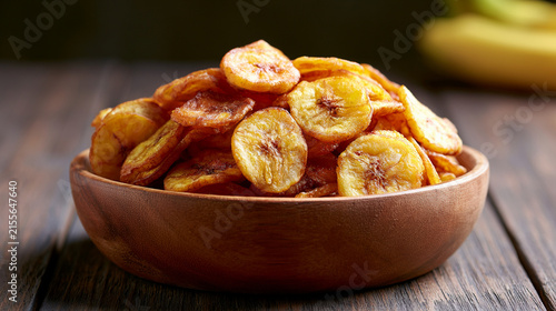 Bowl of crispy fried banana chips on a rustic wooden table