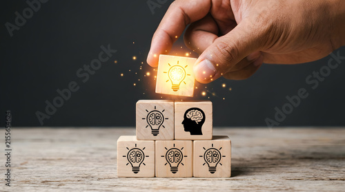 Person hand stacking wooden blocks with business icons for growth and strategy