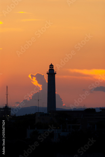 Faro silhouette al tramonto con cielo arancione infuocato
