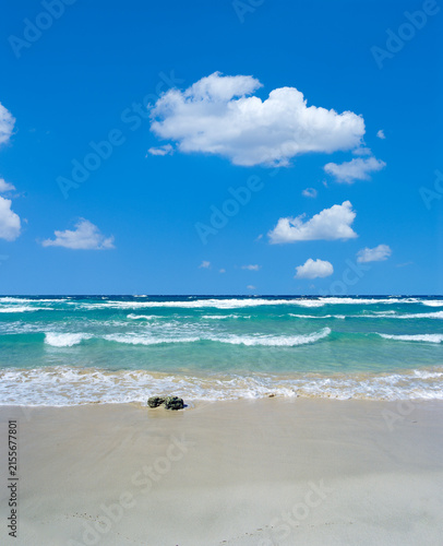 Mare cristallino turchese con roccia e cielo azzurro