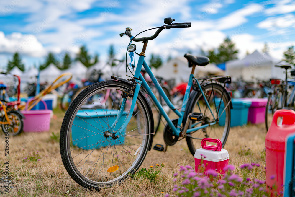Fototapeta premium Juneteenth yard sale display with vintage bicycles, outdoor equipment and storage bins arranged in perfect order, bright blue sky, clean commercial aesthetic, captured with exceptional clarity and