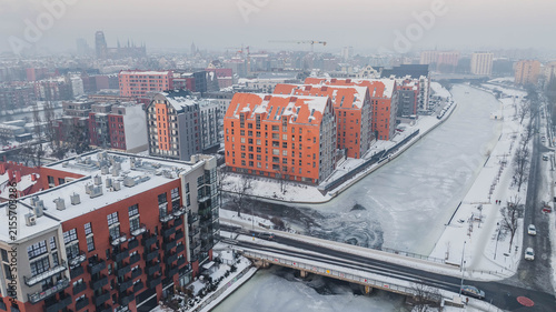 Принти на полотні Aerial view of Dolne Miasto in Gdańsk, Poland, covered in snow, showing historic brick buildings, residential streets, industrial architecture and ongoing urban development