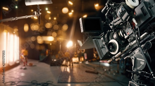 Professional cinema camera on film set with lighting equipment, movie production behind the scenes, broadcasting television studio recording, filmmaking industry creative process