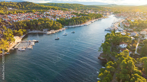 High angle drone shot displays stunning coastal landscape of Hvar Island. Panorama includes historic Stari Grad port