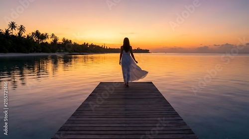Woman on wooden pier at sunset.
