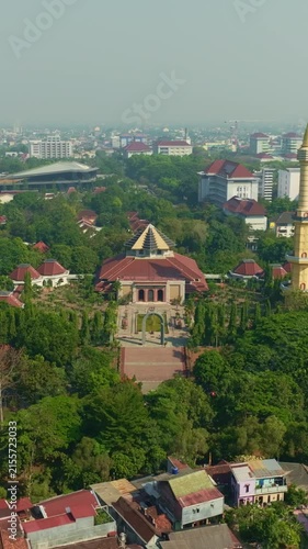 Mosque and minaret rising above green urban Yogyakarta cityscape