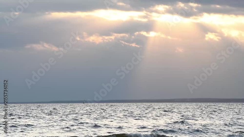 sunset background on bay with sun rays through clouds