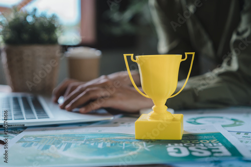 Quadro su tela ESG achievement and sustainability award concept, yellow trophy on environmental social governance corporate report with professional typing on laptop for green business goal and excellence success