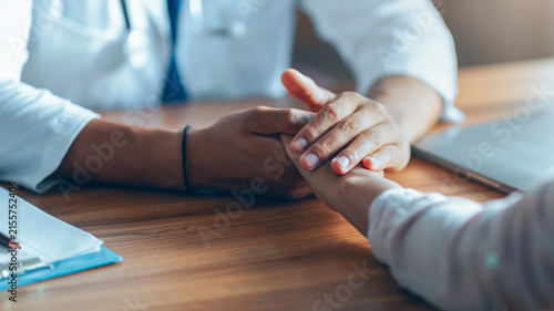 Cuadro en lienzo Concerned Doctor Supporting Patient By Holding Their Hand During Consultation In Medical Office, Establishing Trust And Compassionate Communication