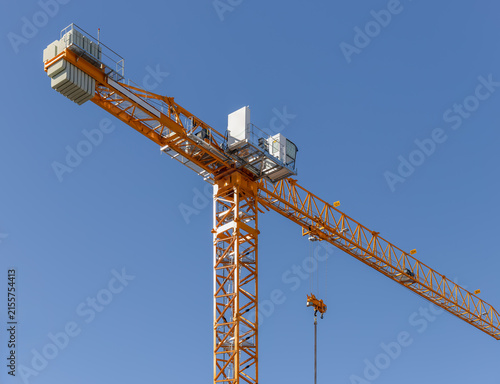 Фотография Yellow tower crane standing tall against a clear blue sky
