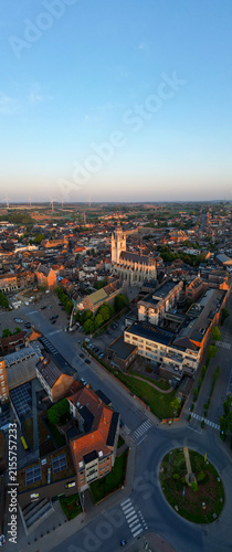 Halle, Vlaams Brabant, Belgium, 27th of April, 2025, A breathtaking aerial photograph captures a magnificent cityscape illuminated by the warm, soothing glow of the sunset