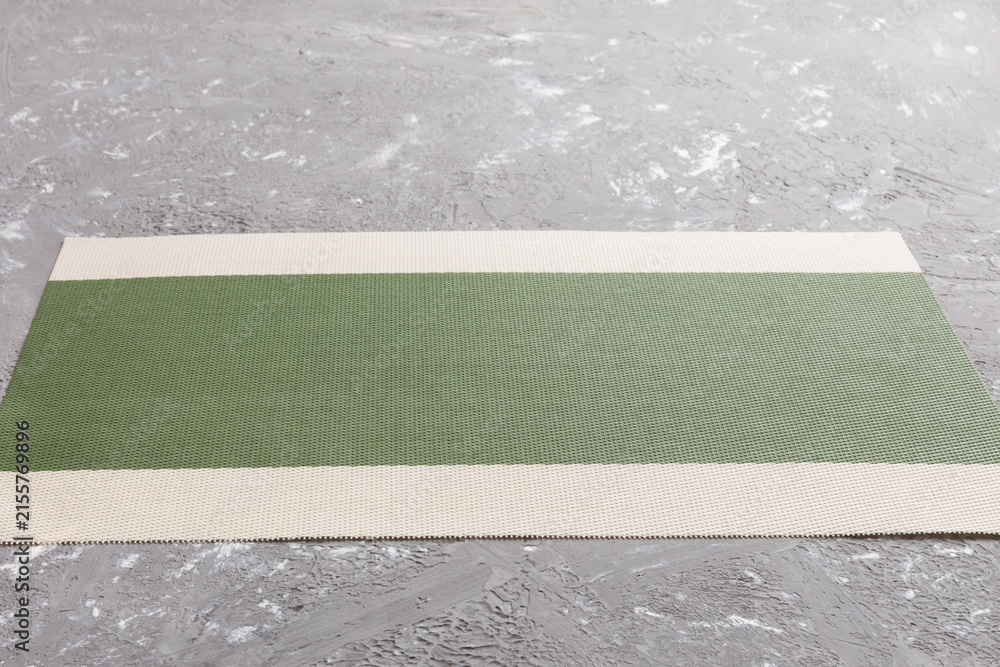 Fototapeta premium Perspective view of green tablecloth for food on cement background. Empty space for your design