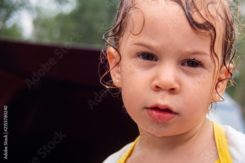 Child with wet hair gazes at viewer