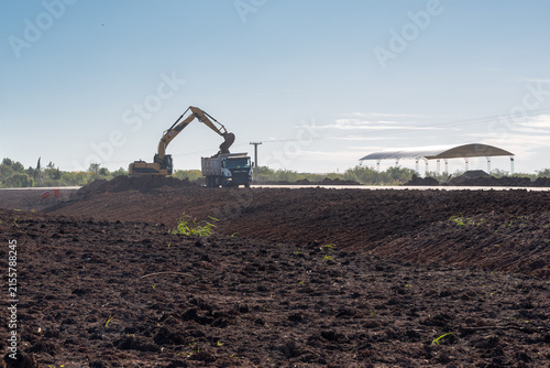 Canvastavla Yellow hydraulic excavator loading soil onto a tipper dump truck at earthworks s