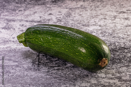 Принти на полотні One fresh green zucchini, a whole raw courgette vegetable, on a textured grey ba