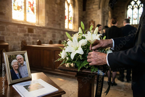 Mourner Arranging White Lilies At Church Memorial Elderly Couple Portrait