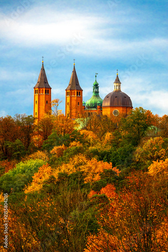 Quadro su tela Historical Plock Cathedral on Tumskie Hill surrounded by colorful autumn forest foliage