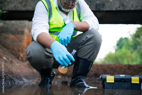 Canvas Print Scientists collecting water samples from the canal in test tubes sample for qual