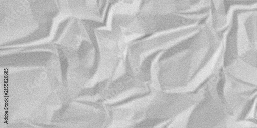 Abstract texture of crumpled white paper or fabric, closeup view of soft folds and shadows with a grainy surface effect