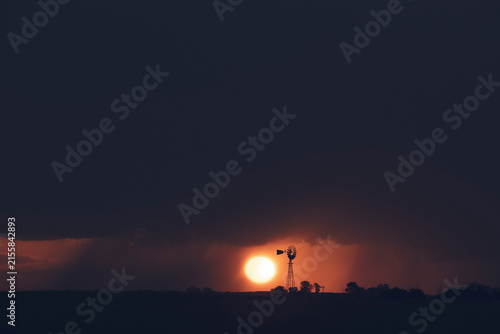 Windmill at sunset with a rain storm in the background, Pampas, Patagonia,Argentina.