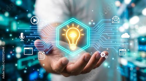 Businessman hand presents a glowing lightbulb idea icon surrounded by digital circuit graphics.