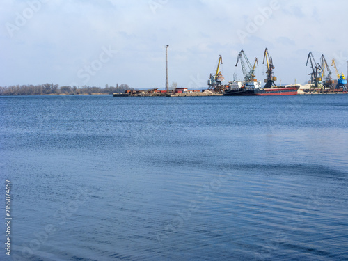 фотографія Calm waters of Dnipro River near fright port with powerful cranes, Zaporizhzhia,