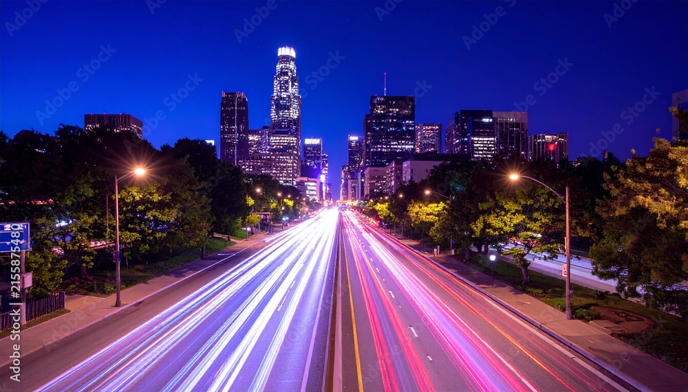 Obraz premium Street scene at night in a city showcasing captivating light trails from vehicles, concept of time