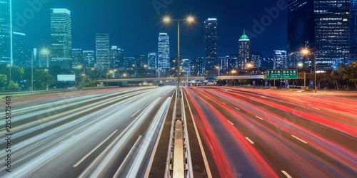 City highway at night with blurred traffic light streaks exposure transportation downtown metropolis infrastructure vehicles movement velocity nighttime skyscrapers waypoint exterior