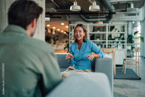 Konstfotografi Asian businesswoman discussing with male colleague in modern office, having a se