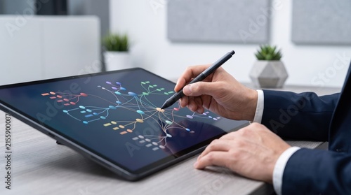 Business professional drawing flowchart on tablet with stylus pen, strategic planning and workflow diagram, corporate management analysis and project organization in modern office