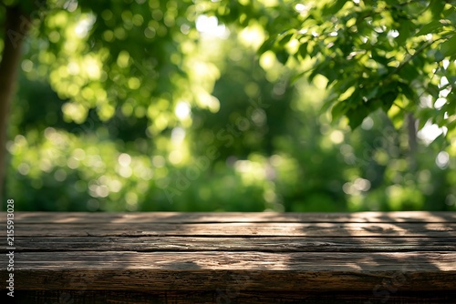 Empty rustic wooden table surface with blurred green nature background and sunlight bokeh