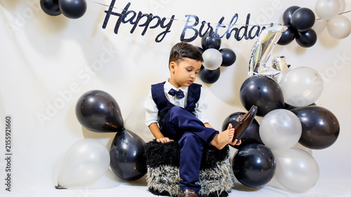 Young Boy holding shoe with Birthday Balloons and Happy Birthday Decoration