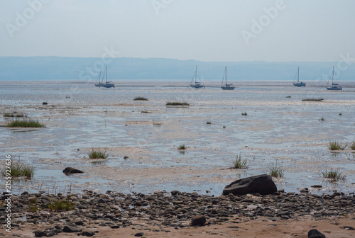 Boats moored on beach at low tide, Thurstaton, The Wirral, UK