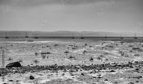Boats moored on beach at low tide, Thurstaton, The Wirral, UK