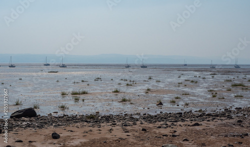 Boats moored on beach at low tide, Thurstaton, The Wirral, UK