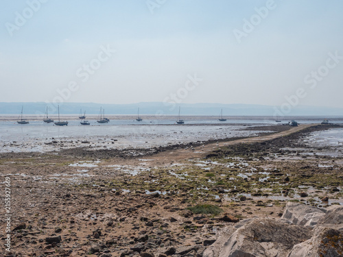 Boats moored on beach at low tide, Thurstaton, The Wirral, UK
