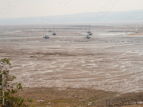 Boats moored on beach at low tide, Thurstaton, The Wirral, UK