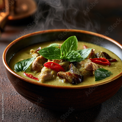 A bowl of flavorful green curry with herbs and spices, steaming and ready to enjoy.