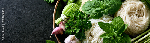 A vibrant array of fresh herbs and noodles arranged beautifully for a culinary delight.
