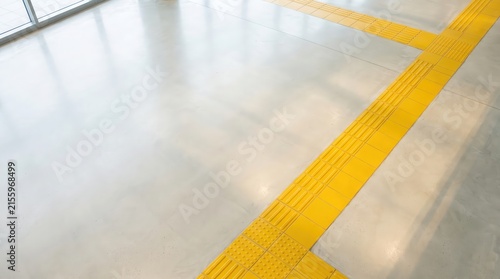 Bright modern interior with yellow tactile floor tiles and sunlight reflection for accessible design