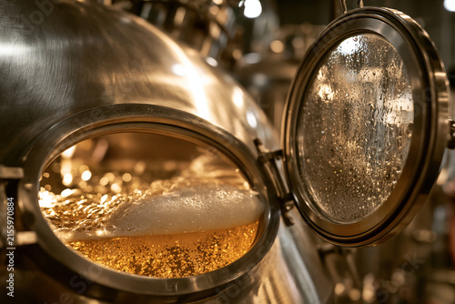 Obraz na płótnie A steaming liquid bubbles inside a shiny metallic brewing vessel.