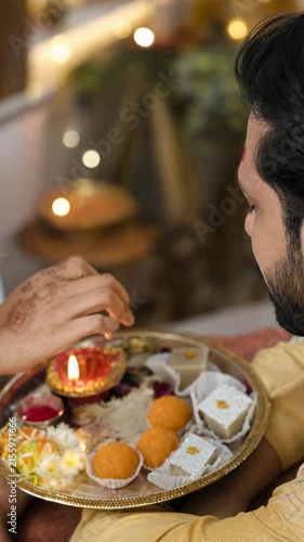 Woman applying tilak during a traditional Indian festival ritual
