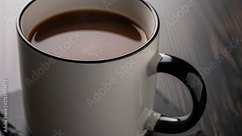 White ceramic mug filled with fresh black coffee.