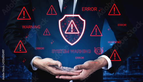 Fotografie A businessman displays a glowing shield surrounded by system warning alerts, symbolizing the importance of cybersecurity and proactive risk management in modern digital environments