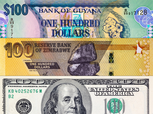 Different 100 Dollars banknotes from the USA, Guyana, and Zimbabwe. Global variety of the dollar as a monetary unit.