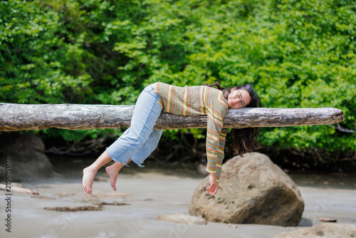 Fotografía Girl laying on log in summer sun, Haida gwaii