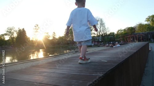 Toddler walking on lakeside pier