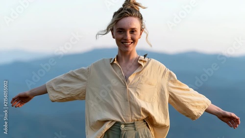 Woman with outstretched arms enjoying a mountain view for wellness banner and scenic nature background use